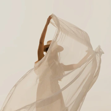 Woman lifting a piece of light fabric